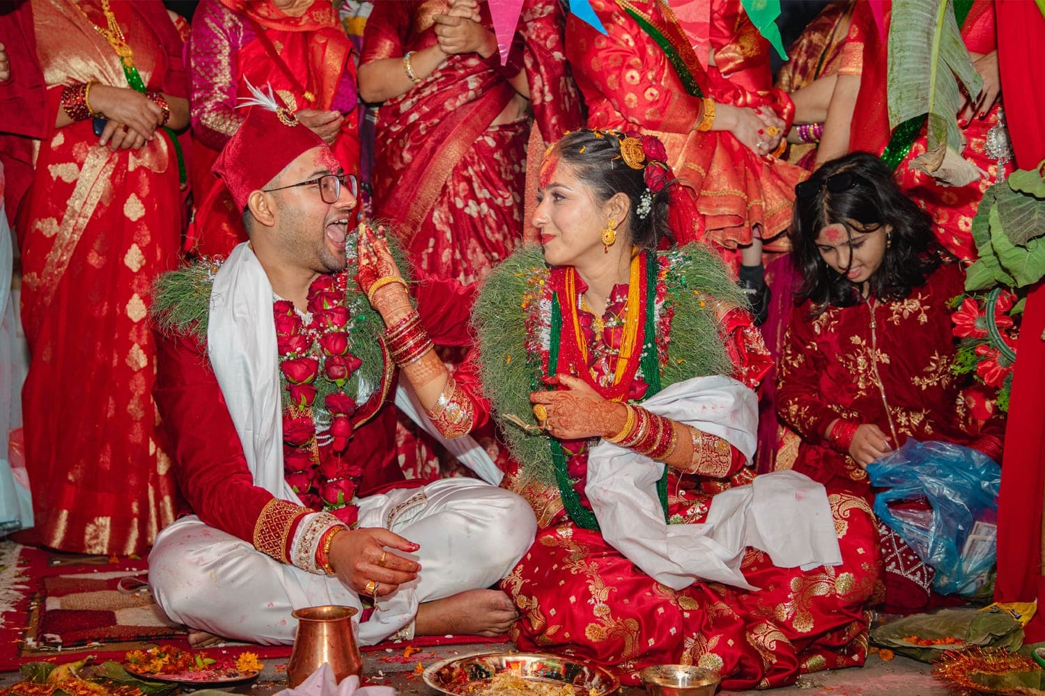 A bride and groom sit side by side at the mandap during a Hindu wedding ceremony